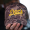 Doc's Diesel Camo Trucker Hat being held by a man