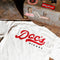 Doc's Diesel Tan Staple T-Shirt in a mechanic's shop